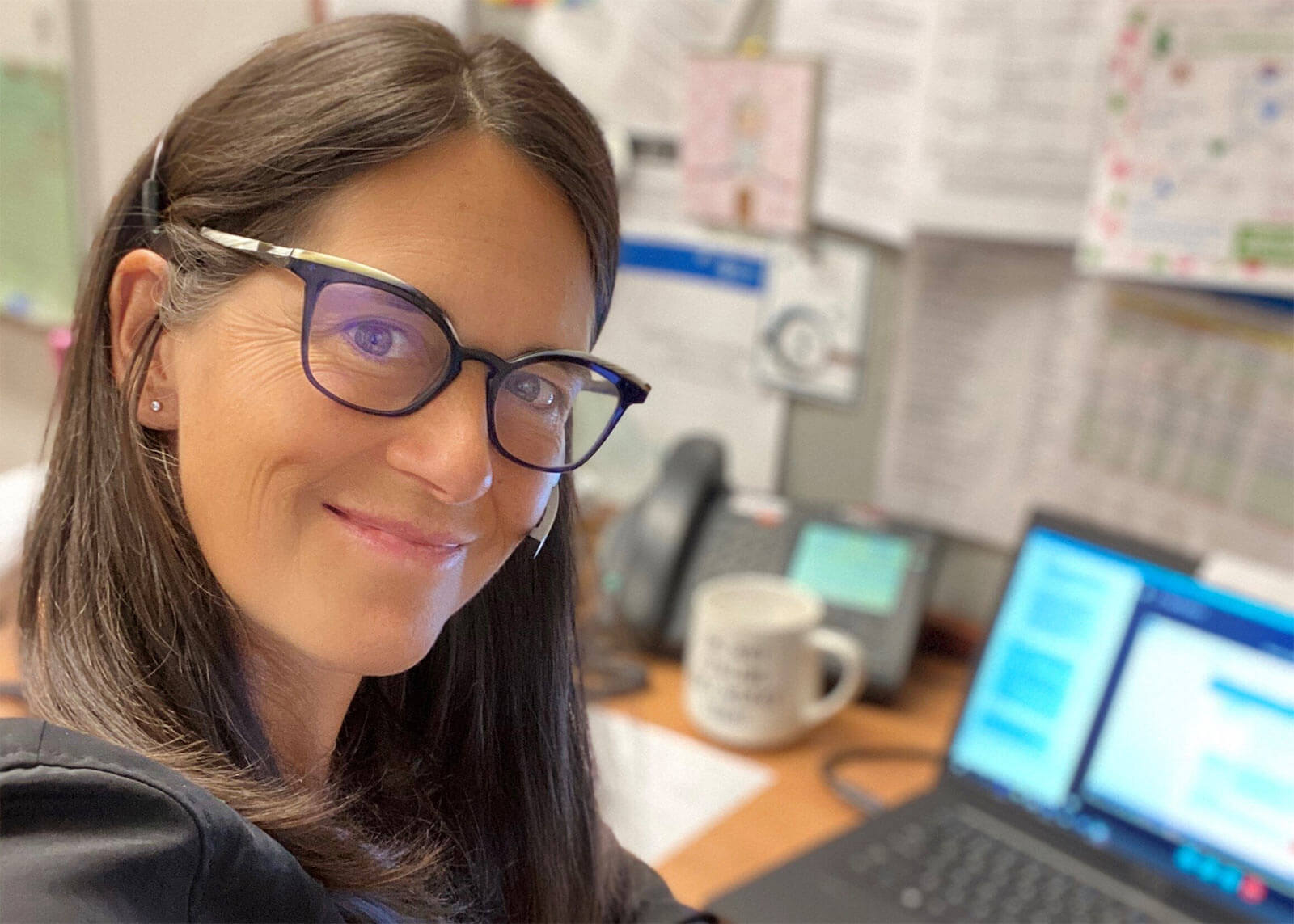 Dr. Amanda Brisebois in front of a laptop on an office desk