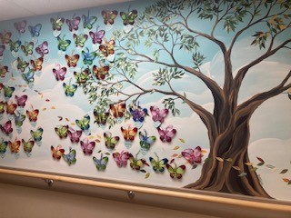 Painted mural of a tree and a kaleidoscope of butterflies