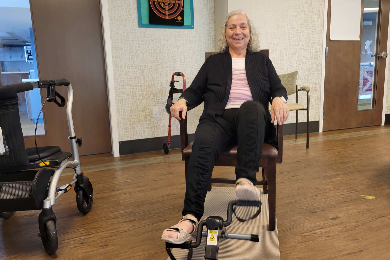 Senior woman sitting and pedaling an exercise bike