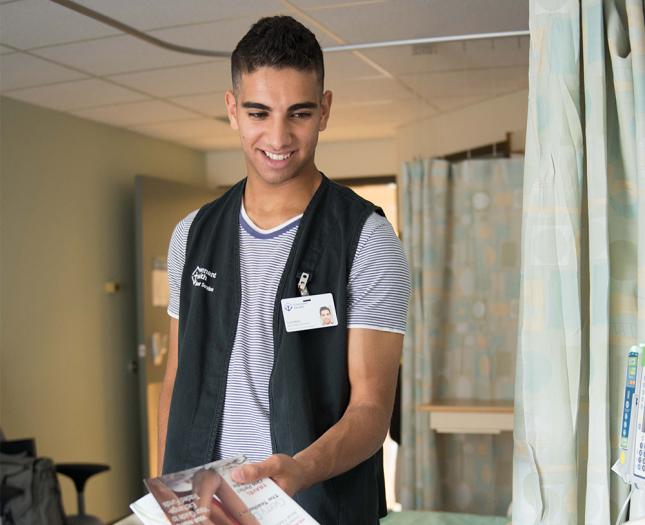 A volunteer hands a patient a magazine