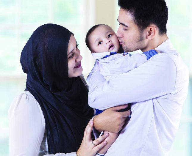 A couple cuddles their newborn baby