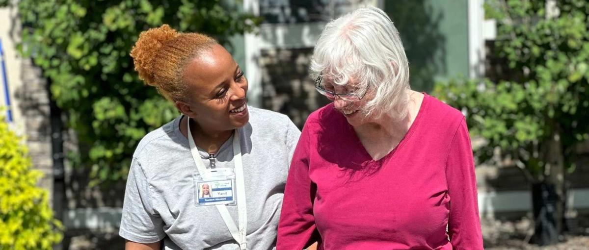 Health care aide walking with a senior