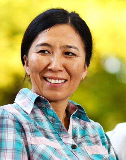 Two smiling women giving eye contact to a third as she speaks