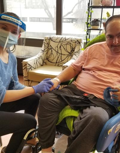 Margaret holds a resident's hand at the Edmonton General