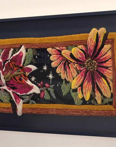 Artwork depicting stargazer lilies and asters created from yarn